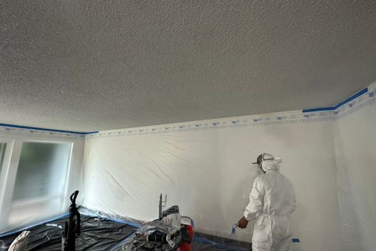 Professional spraying popcorn ceiling for removal